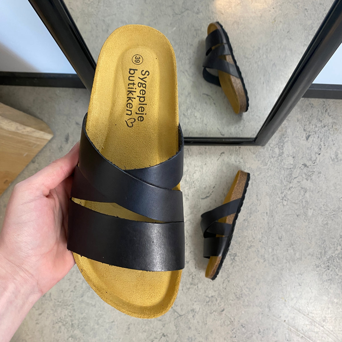 Slip on sandal i sort glat skind med krydsremme – komfort og støtte