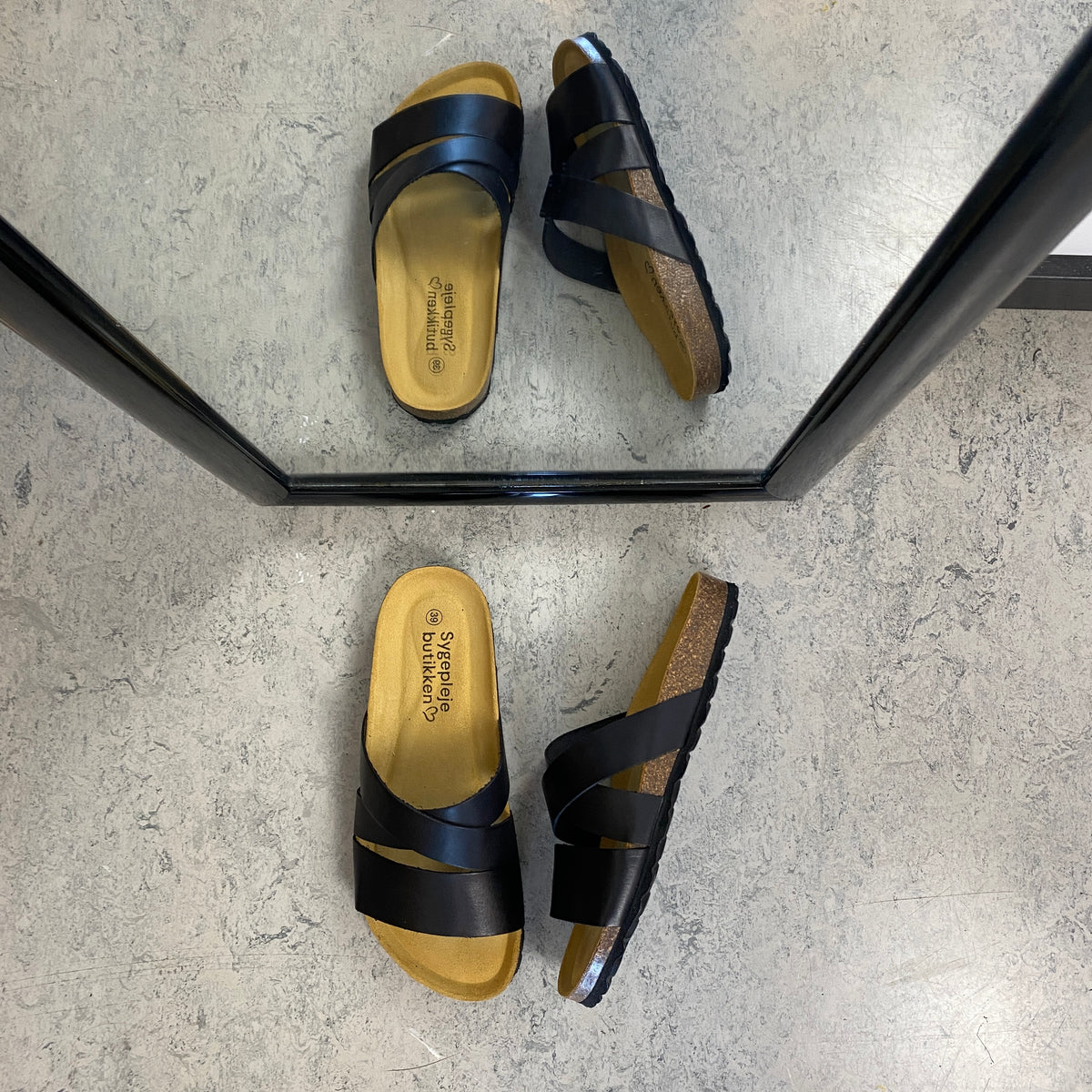 Slip on sandal i sort glat skind med krydsremme – komfort og støtte