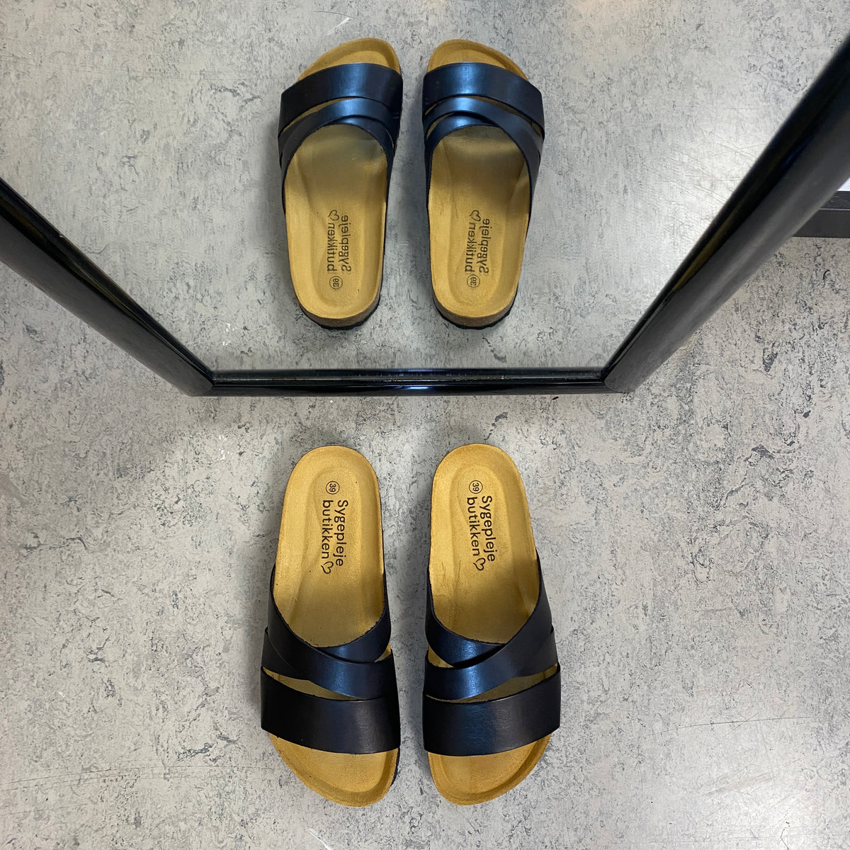 Slip on sandal i sort glat skind med krydsremme – komfort og støtte